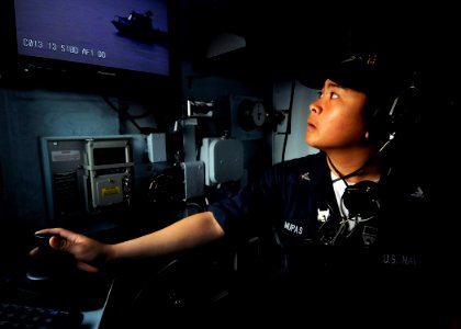 US Navy 090226-N-3830J-079 Operations Specialist 3rd Class Glenn Mupas, assigned to the amphibious command ship USS Blue Ridge (LCC 19), changes the view on the camera to observe an approaching security boat