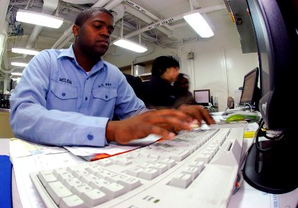 US Navy 090226-N-9928E-036 Personnel Specialist Seaman Orvin McLean uses a keyboard to enter personnel data into Sailors digital service records photo