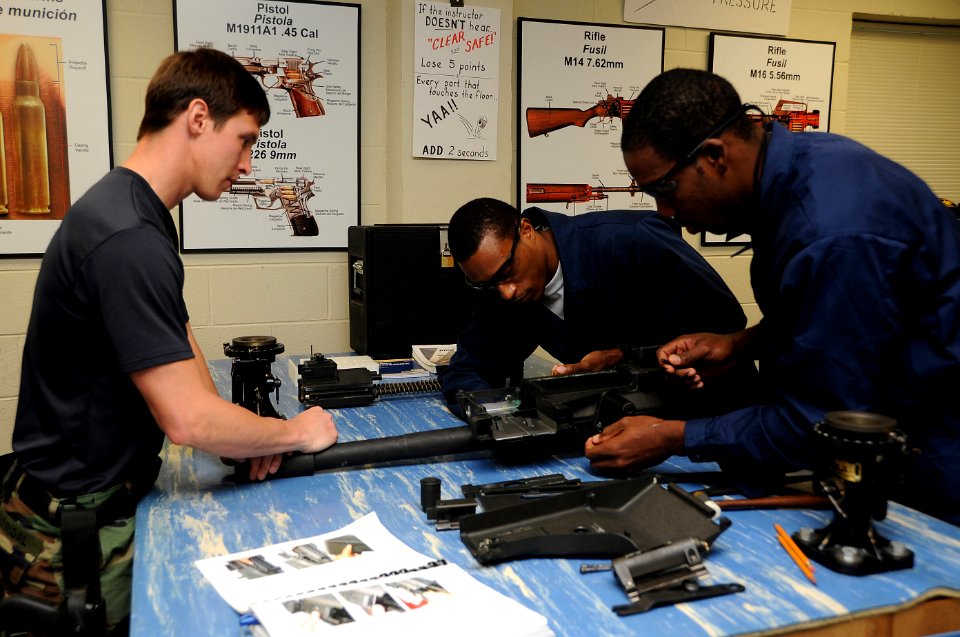 US Navy 090304-N-4205W-131 Special Warfare Boat Operator 1st Class Raul Madrigal instructs Police Constable Henry Sharm-Mion and Able Seaman Julio Charles on the correct assembly of a M19 grenade machine gun