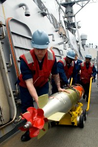 US Navy 090304-N-9123L-006 Sailors aboard the guided-missile destroyer USS John S. McCain (DDG 56) maneuver a recovered training torpedo after completing a torpedo exercise