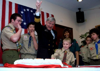 US Navy 090228-N-2013O-060 Rear Adm. James D. Kelly cuts the celebratory cake with the help of local scouts after receiving the Distinguished Eagle Scout Award