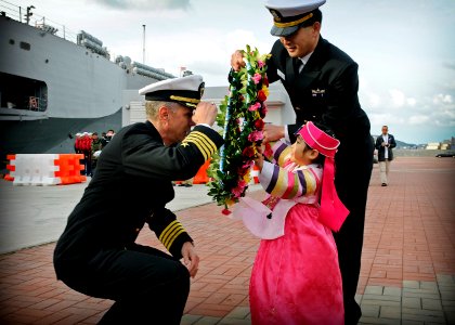 US Navy 090305-N-3830J-031 Capt. Thom W. Burke, left, commanding officer of the amphibious command ship USS Blue Ridge (LCC 19), receives a flower wreath from the daughter of a Republic of Korea naval officer