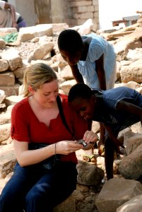 US Navy 090302-N-1688B-082 Sarah Gloo, an Africa Partnership Station staff member embarked aboard the amphibious transport dock ship USS Nashville (LPD 13), shows Ghanaian children their picture while visiting a fishing village