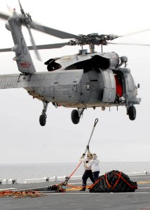 US Navy 090304-N-0515W-030 Sailors assigned to the combat cargo department attach cargo nets and cables to an MH-60S Sea Hawk helicopter during an underway ammunition onload aboard the amphibious assault ship USS Bonhomme Richa