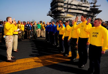 US Navy 090306-N-7571S-001 Flight deck officer Lt. Cmdr. Ronald Rancourt and shooter Lt. Jade Maguigad re-enlist 11 Aviation Boatswain's Mates (Handling) aboard the aircraft carrier USS Theodore Roosevelt (CVN 71)