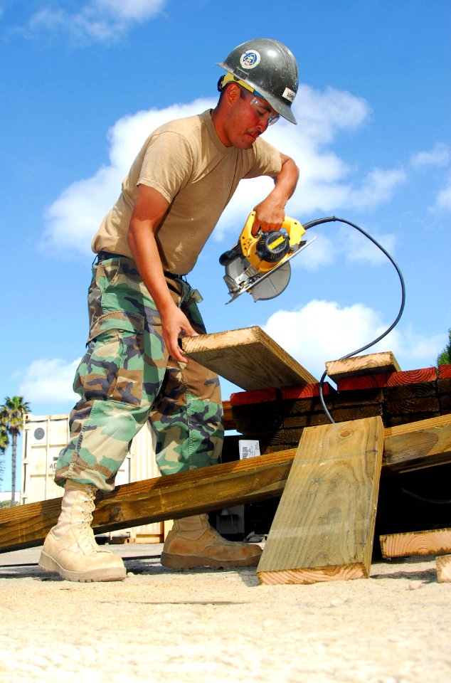 US Navy 090305-N-5617R-002 Builder 3rd Class Joseph Lopez cuts a piece of wood