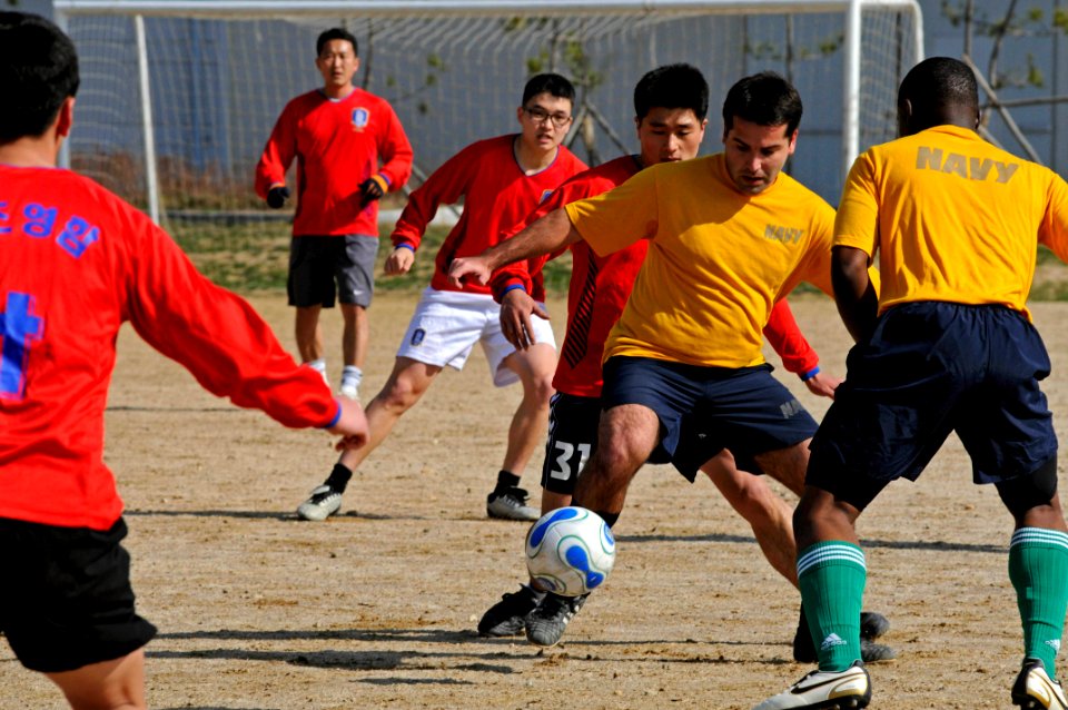 US Navy 090308-N-3830J-066 Yeoman 1st Class Andre Dortrait, assigned to the amphibious command ship USS Blue Ridge (LCC 19) maneuvers between Republic of Korea Navy soccer team members during a soccer game
