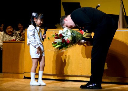 US Navy 090317-N-1251W-002 Capt. Daniel Weed, commander, Fleet Activities Yokosuka, receives a bouquet of flowers from a Seika Kindergarten student during the school's 61st anniversary celebration
