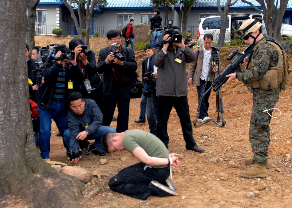 US Navy 090309-N-9573A-011 Cpl. Ian MacDonald, from the Fleet Anti-terrorism Security Team Pacific (FASTPAC), holds a simulated aggressor who broke through the perimeter breech of the base fence line as Republic of Korea media