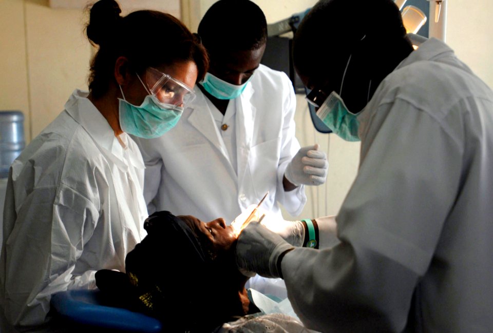 US Navy 090318-N-7948C-060 Lt. Cmdr. Shay Razmi, left, a nurse corps officer deployed with Africa Partnership Station embarked aboard the amphibious transport dock ship USS Nashville (LPD 13), assists in a dental exam