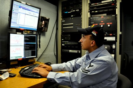 US Navy 090310-D-5972N-005 U.S. Navy Information Systems Technician 2nd Class James Rago troubleshoots the video teleconference system of a video information exchange system photo
