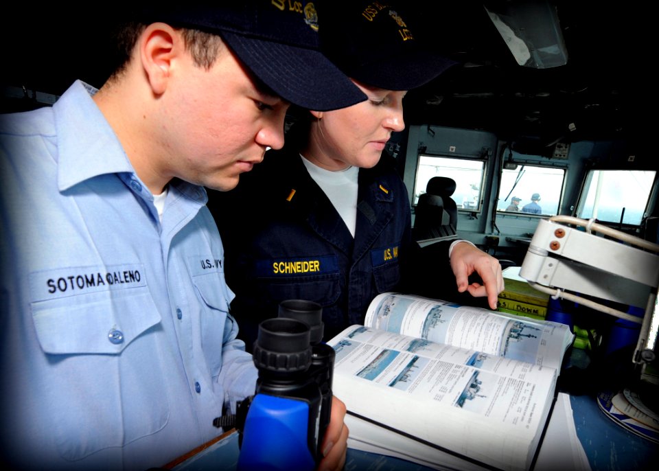 US Navy 090316-N-7280V-006 Ensign Laura Schneider explains to Hull Technician 3rd Class Ricardo Sotomagdaleno how to look up surface contacts