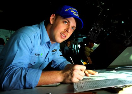 US Navy 090317-N-7571S-002 Quartermaster 3rd Class Christopher McGrew, quartermaster of the watch, writes down the ship's position while in the navigation bridge aboard the aircraft carrier USS Theodore Roosevelt (CVN 71)