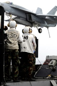 US Navy 090319-N-3610L-615 Sailors watch as an F-A-18E strike fighter makes an arrested landing
