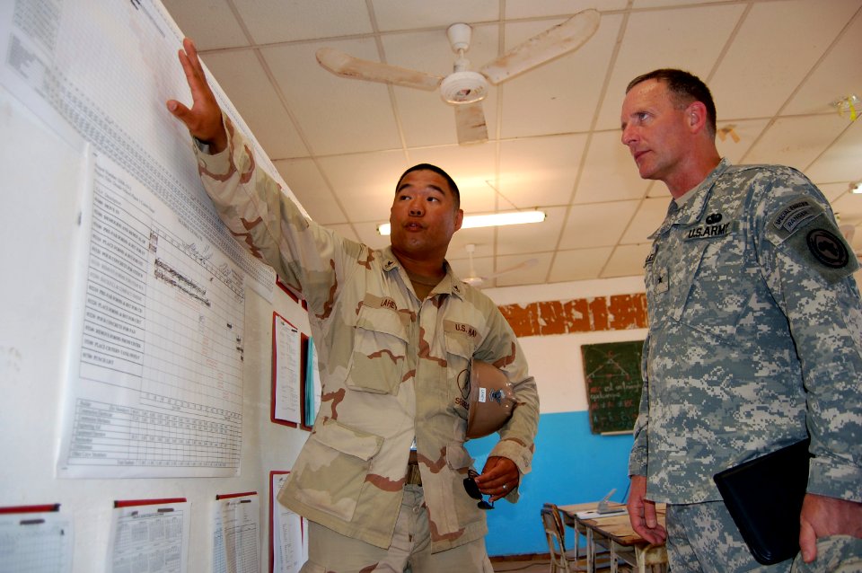 US Navy 090321-N-1057H-029 onstruction Electrician 2nd Class Mark R. Lahey explains construction scheduling to Brig. Gen. Christopher Leins