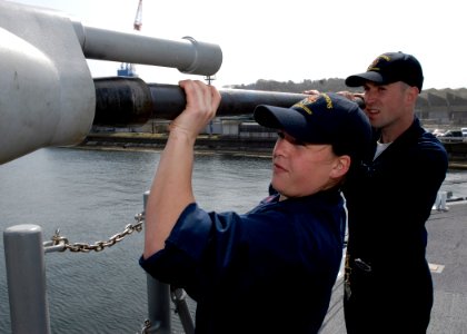 US Navy 090317-N-9520G-021 Gunner's Mate 2nd Class Lenore Manaughboehm and Gunner's Mate 3rd Class Michael Hartley reinstall the barrel of a 25mm chain gun