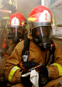 US Navy 090317-N-9134V-009 Culinary Specialist 3rd Class Arturio Cook, front, and Seaman Shawn Fritz simulate firefighting techniques during a general quarters drill aboard the amphibious dock landing ship USS Carter Hall (LSD