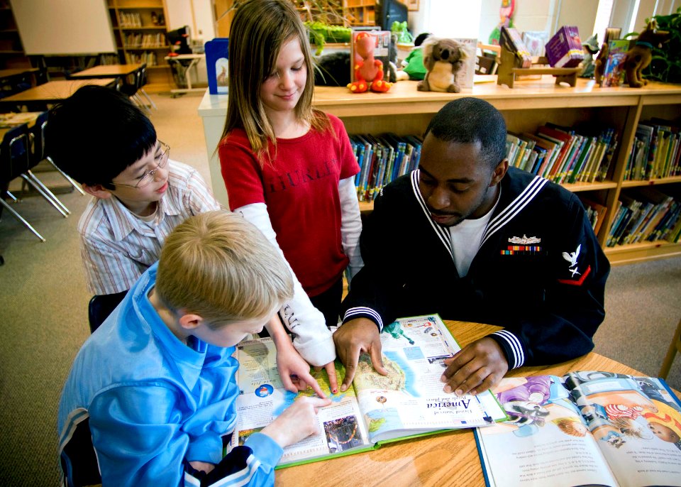 US Navy 090319-N-2953W-001 Cryptologic Technician 3rd Class J'mese White, assigned to Navy Cyber Defense Operations Command, reads to Bayside Elementary School students