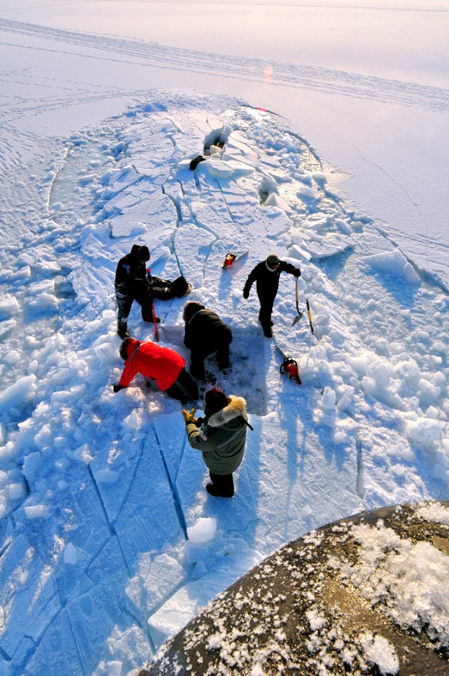 US Navy 090322-N-8273J-350 Members of the Applied Physics Laboratory Ice Station clear ice from the hatch of the Los Angeles-class submarine USS Annapolis (SSN 760) after the sub broke through the ice while participating in Ice