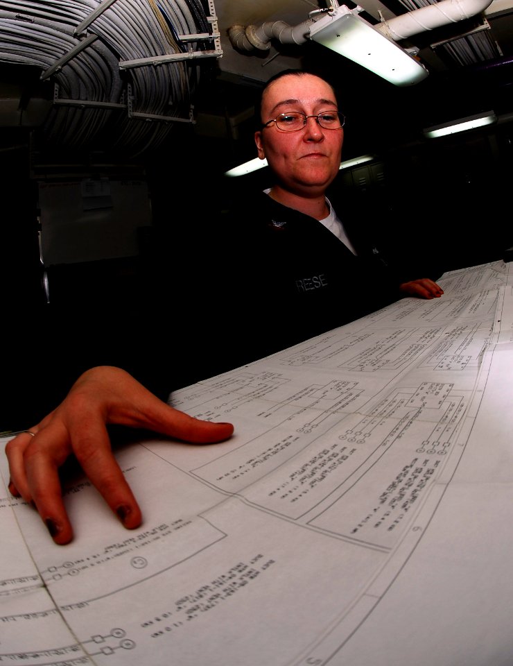 US Navy 090318-N-9928E-015 Storekeeper 2nd Class Jessica Reese reviews ventilation drawings in the maintenance support center aboard USS John C. Stennis (CVN 74)