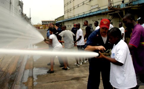 US Navy 090320-N-3316L-061 Machinery Repairman 1st Class Michael Hall, assigned to the amphibious transport dock ship USS Nashville (LPD 13) trains a Nigerian navy member on basic hose handling during an Africa Partnership Stat