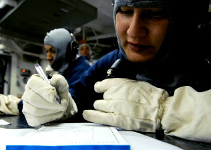 US Navy 090323-N-7478G-055 Mass Communication Specialist 3rd Class Daniel Viramontes writes down a message while communicating on a sound-powered phone in Damage Control Central