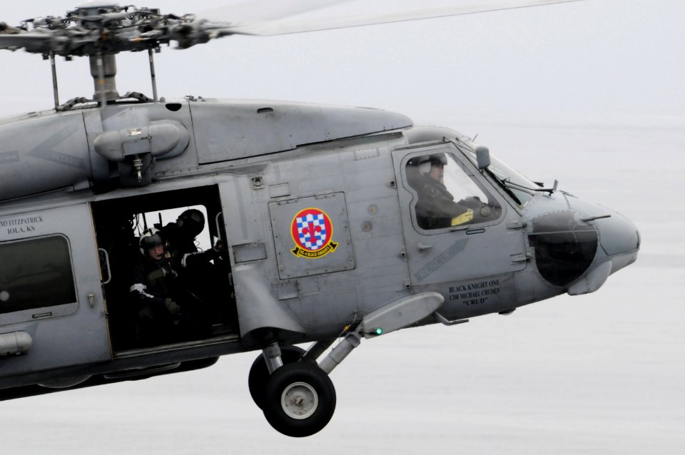 US Navy 090320-N-3659B-287 Naval Air Crewman 3rd Class Kelvin Kolb looks out the door of an SH-60F Seahawk helicopter