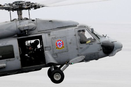 US Navy 090320-N-3659B-287 Naval Air Crewman 3rd Class Kelvin Kolb looks out the door of an SH-60F Seahawk helicopter