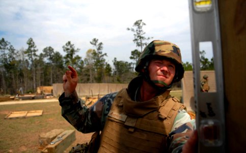 US Navy 090322-N-3674H-156 Builder 1st Class William Potter, assigned to Naval Mobile Construction Battalion (NMCB) 74, ensures the level of a timber tower while directing a forklift during a field training exercise at Camp She photo