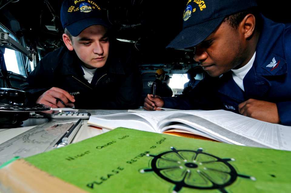 US Navy 090323-N-7478G-012 Quartermaster Seaman Tim Davidson and Quartermaster 3rd Class Dexter McFarland calculate moonrise on the bridge of the amphibious command ship USS Blue Ridge (LCC 19)