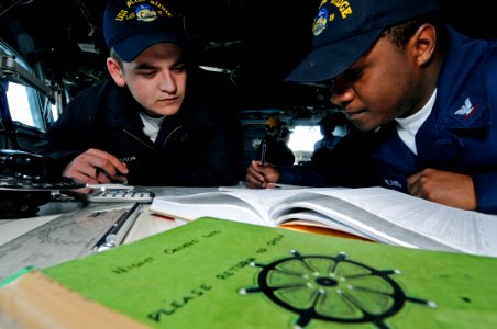 US Navy 090323-N-7478G-012 Quartermaster Seaman Tim Davidson and Quartermaster 3rd Class Dexter McFarland calculate moonrise on the bridge of the amphibious command ship USS Blue Ridge (LCC 19)