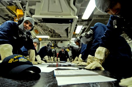 US Navy 090323-N-7478G-033 Sailors simulate bracing for shock in Damage Control Central during a general quarters drill aboard the amphibious command ship USS Blue Ridge (LCC 19)