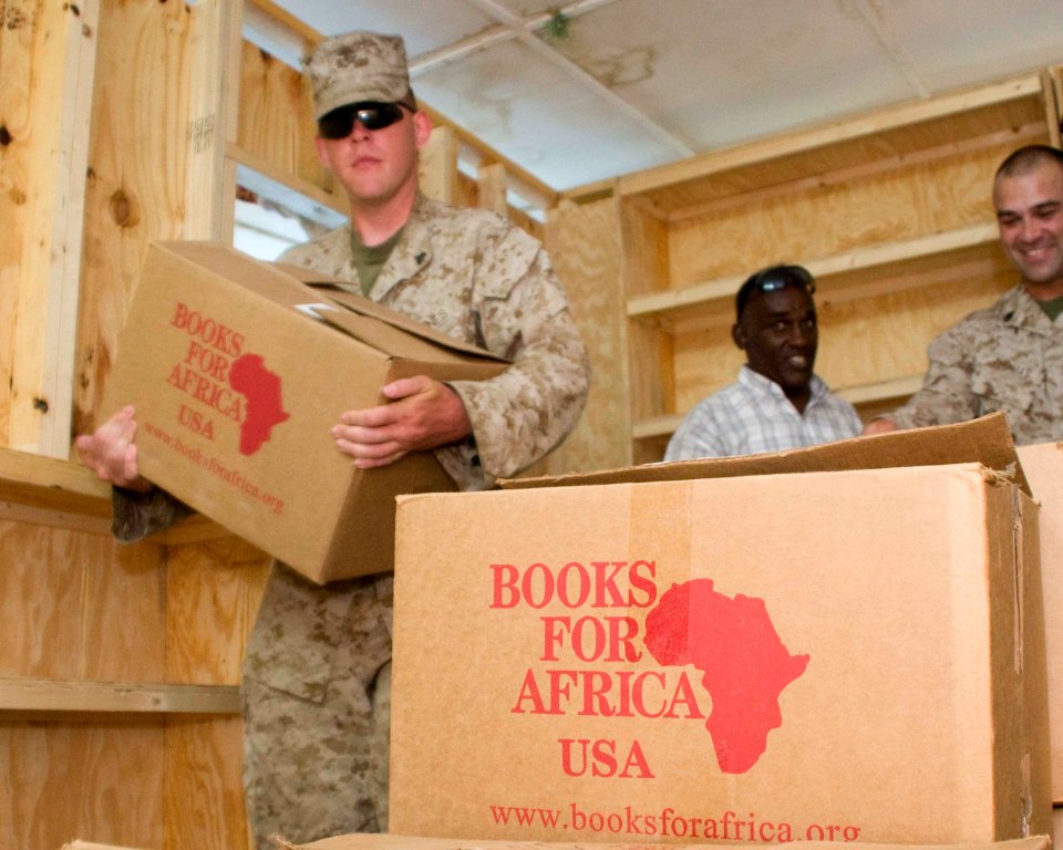 US Navy 090326-N-9552I-013 Marine Lance Cpl. Mark Kuhn, assigned to the Marine 9th Provisional Security Force (9th PSF), stationed in St. Paul, Minn., unloads cases of educational books for the Damerjog Schoolhouse