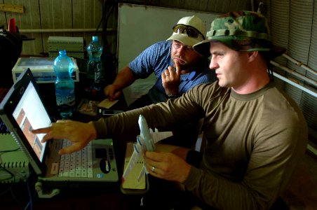 US Navy 090328-N-5242D-028 Sonar Technician (Surface) 2nd Class Dan Simmering, right, shows Tad, a Uganda-based government contractor, what he believes to be a similarity between a sonar reading and a 1-200 scale model of the I
