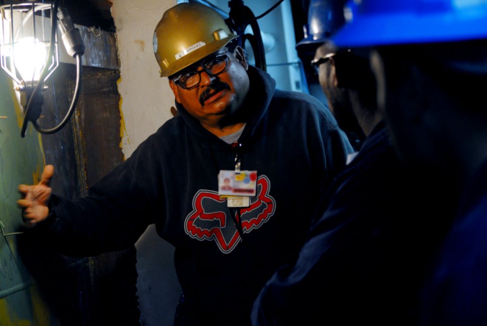 US Navy 090325-N-9689V-002 General Dynamics NASSCO engineer Eugene Rodriguez and Sailors assigned to the amphibious transport dock ship USS Dubuque (LPD 8) discuss the most effective way to cut a hole in the hull of the ship to