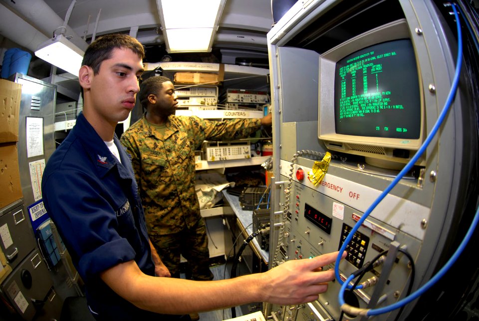 US Navy 090326-N-2475A-038 Aviation Electronics Technician 3rd Class John Blackwood, left, from San Angelo, Texas, sends signals to a data link radio