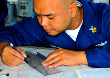 US Navy 090326-N-4774B-071 Quartermaster 1st Class Howell Trinidad marks measurements on a chart aboard the guided-missile cruiser USS Lake Champlain (CG 57) while off the coast of Iraq
