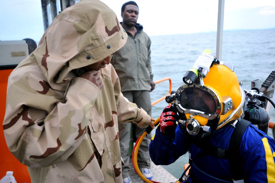 US Navy 090329-N-5242D-050 Navy Diver 3rd Class Alberto Alejo, helps Master Chief Navy Diver Arne Phillips check his gear prior to diving into Africa's Lake Victoria
