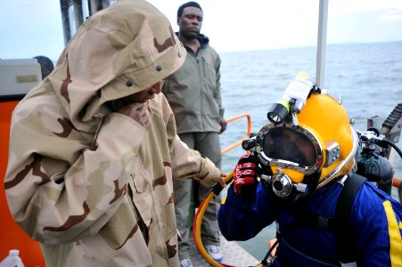 US Navy 090329-N-5242D-050 Navy Diver 3rd Class Alberto Alejo, helps Master Chief Navy Diver Arne Phillips check his gear prior to diving into Africa's Lake Victoria