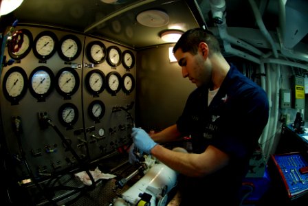 US Navy 090327-N-0096C-014 Aviation Structural Mechanic 2nd Class Brandon Fournier, from Fall River, Mass., tests an auxiliary power unit accumulator photo