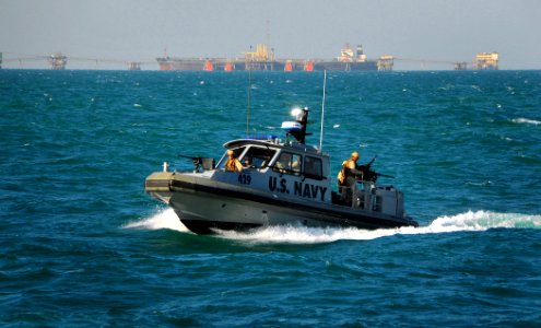 US Navy 090326-N-4774B-041 A Navy patrol boat assigned to Inshore Boat Unit (IBU) 22 approaches the guided-missile cruiser USS Lake Champlain (CG 57) as it patrols the waters surrounding the Al Basra Oil Terminal off the coast