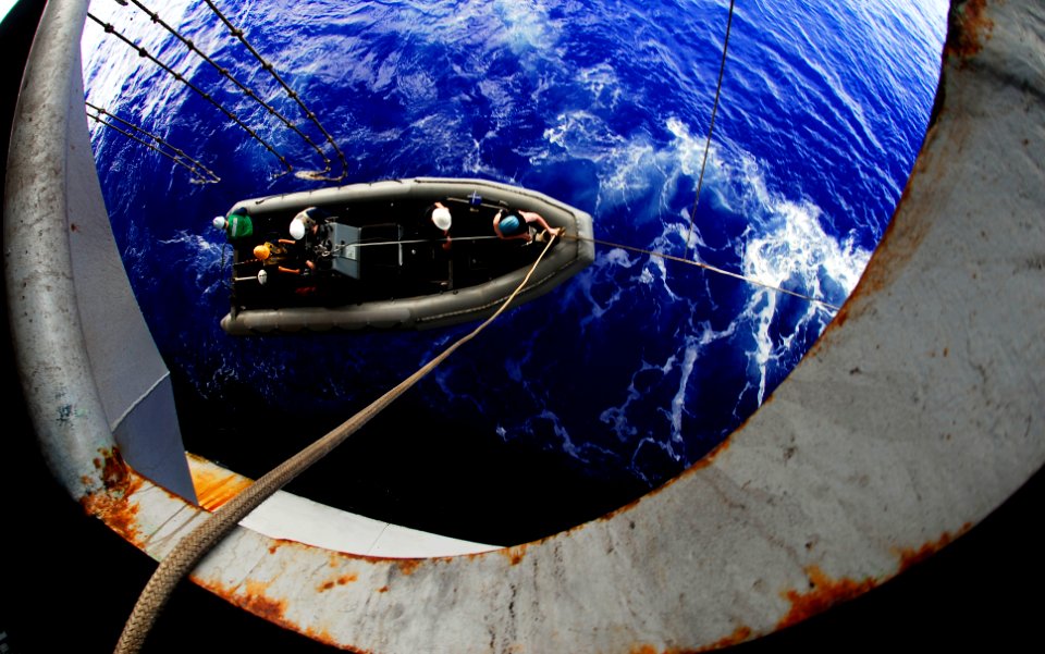 US Navy 090327-N-9928E-016 Sailors from deck department manning a rigid-hull inflatable boat are lowered into the ocean from the portside boat deck during a man overboard drill aboard the Nimitz-class aircraft carrier USS John