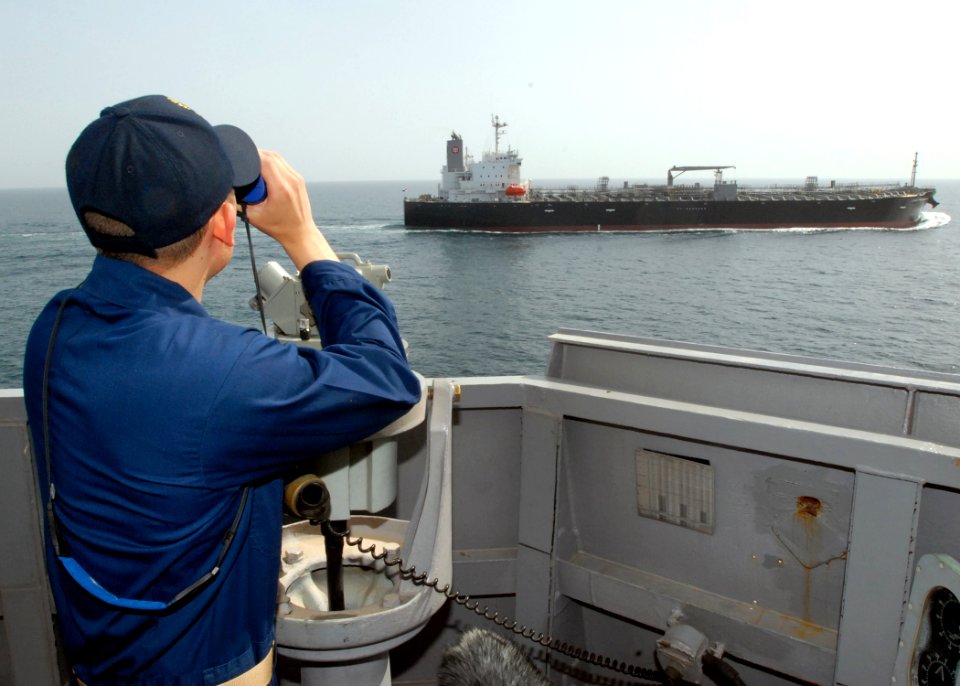US Navy 090329-N-0803S-017 An officer standing watch aboard the guided-missile destroyer USS Paul Hamilton (DDG 60) observes an oil tanker pass