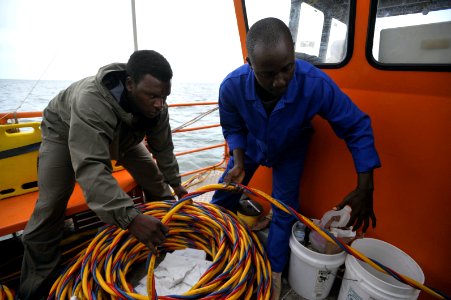 US Navy 090329-N-5242D-120 Navy Diver 2nd Class Ellex Sturkey and Uganda Peoples' Defence Air Force Lt. Robert Kijjali put away gear after one of Sturkey's colleagues completes a dive into Africa's Lake Victoria