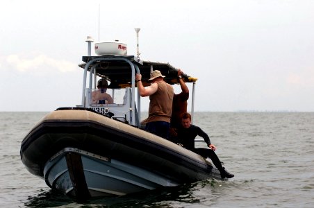 US Navy 090328-N-5242D-231 Explosive Ordnance Disposal Technician 2nd Class John Handrahan climbs into a rigid-hulled inflatable boat after completing a dive into Africa's Lake Victoria