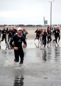 US Navy 090329-N-2959L-318 An individual competitor races through the surf ahead of relay competitors during the 31st annual SUPERFROG Triathlon at Silver Strand State Beach