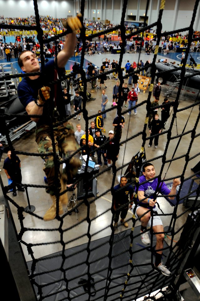 US Navy 090402-N-4515N-144 A high school wrestler challenges a member of the special warfare community to a race up the cargo net at the Navy SEAL Accelerator during the National High School Wrestling Championships