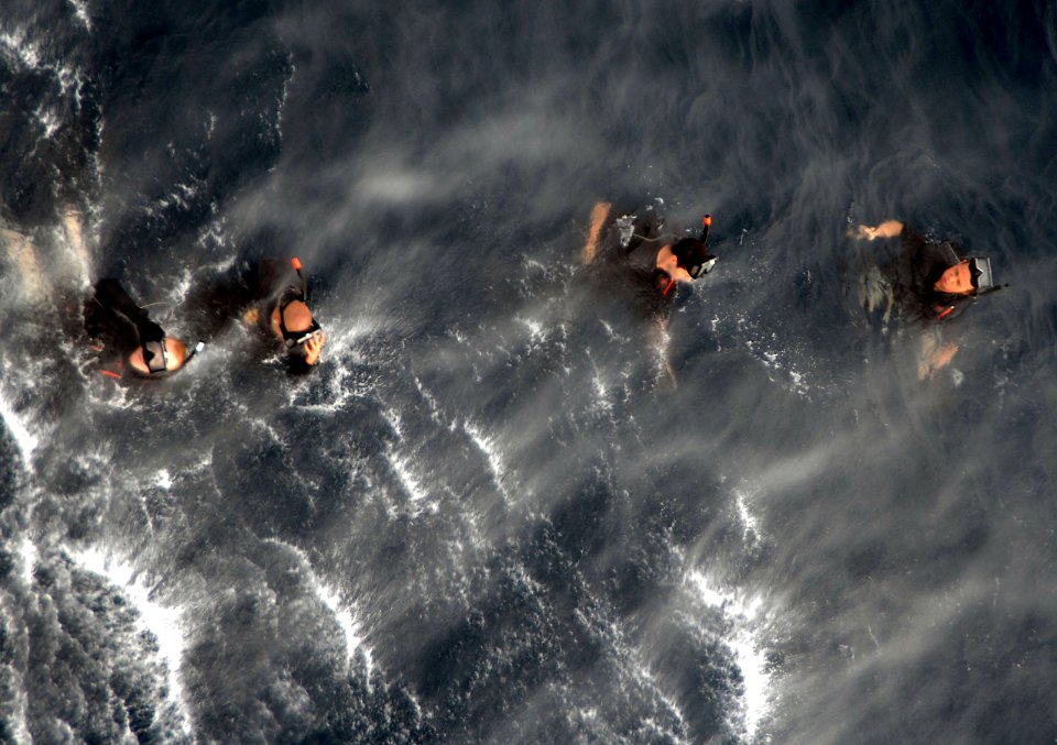 US Navy 090401-N-6639M-324 Search and rescue swimmers assigned to Helicopter Sea Combat Squadron (HSC) 21, Detachment 3 train near the amphibious assault ship USS Boxer (LHD 4)