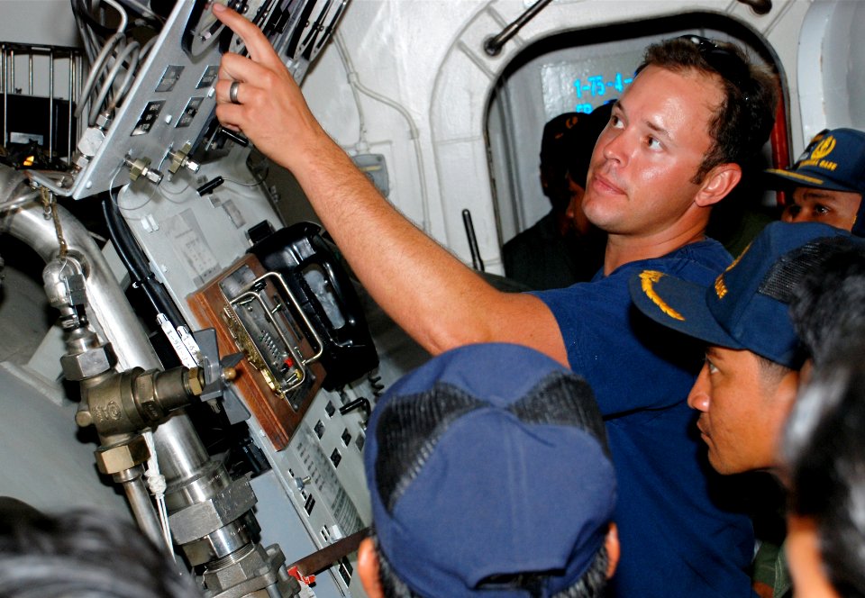 US Navy 090401-N-7095C-003 Navy Diver 1st Class Jacob Eskew, assigned to Mobile Diving and Salvage Unit (MDSU) 1, leads Cambodian divers on a tour of the recompression chamber aboard the Military Sealift Command rescue and salv