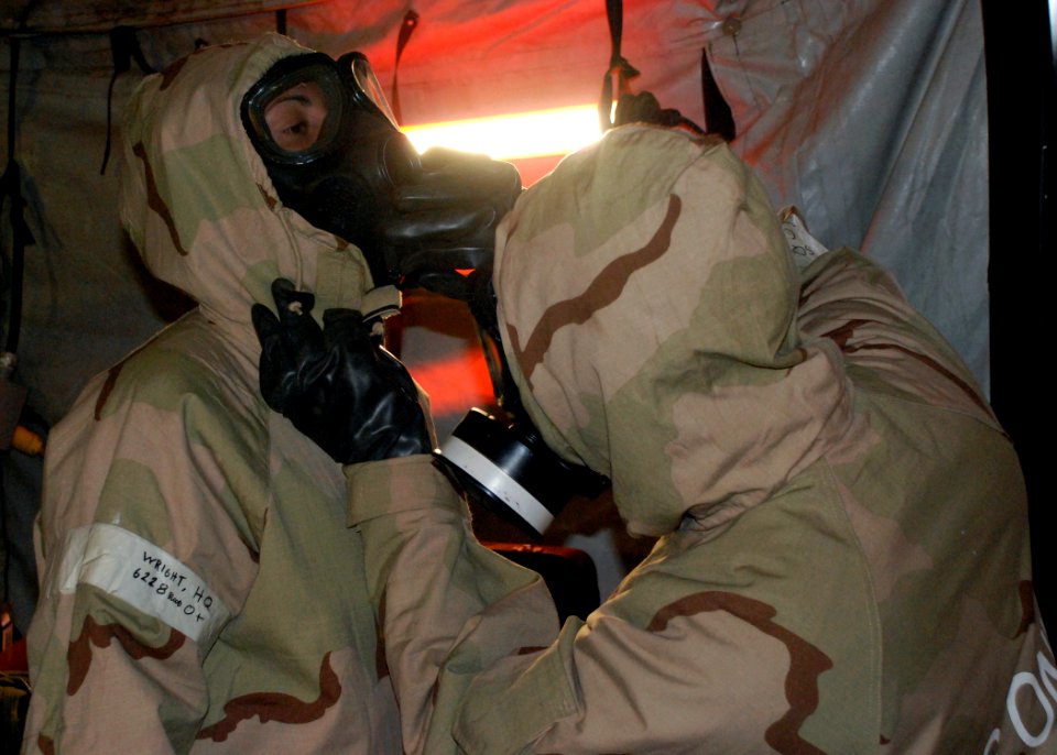 US Navy 090401-N-4973M-006 Yeoman 3rd Class Franco Velasquez, assigned to Amphibious Construction Battalion (ACB) 1, assists Storekeeper Seaman Monica Wright, also assigned to ACB-1, with her mission oriented protective posture